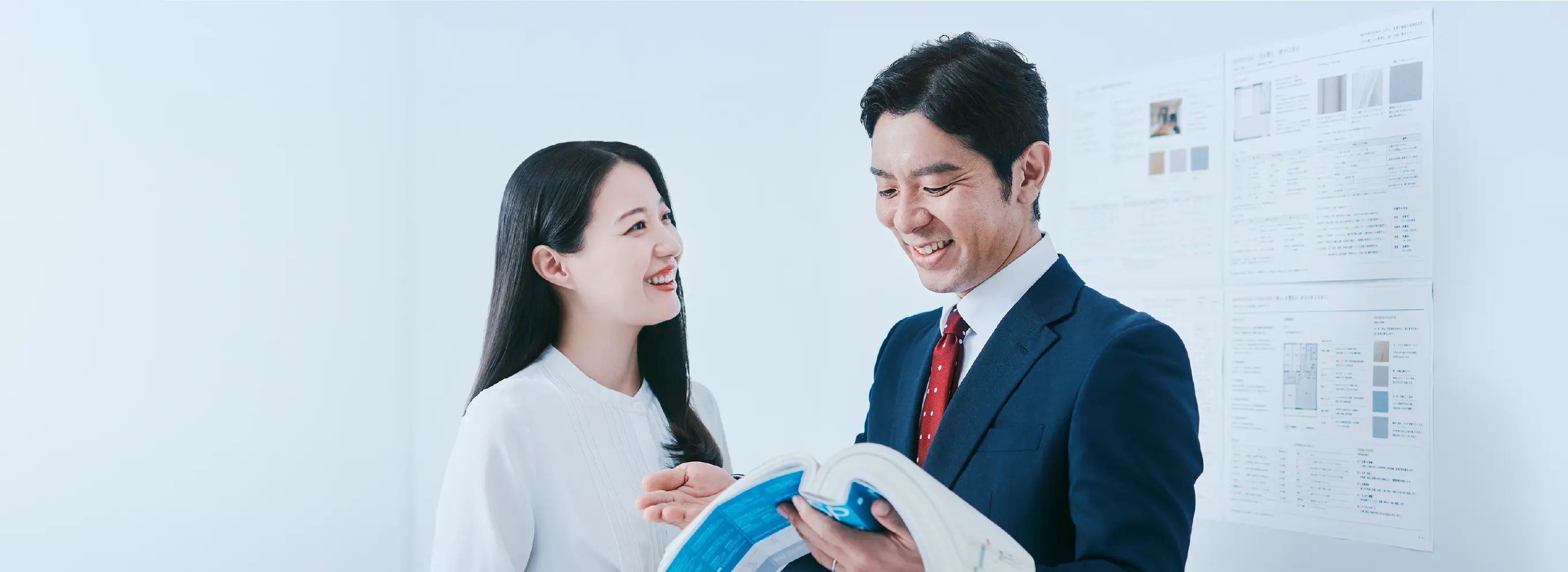 建設資材の前で打ち合わせをする担当者と職人